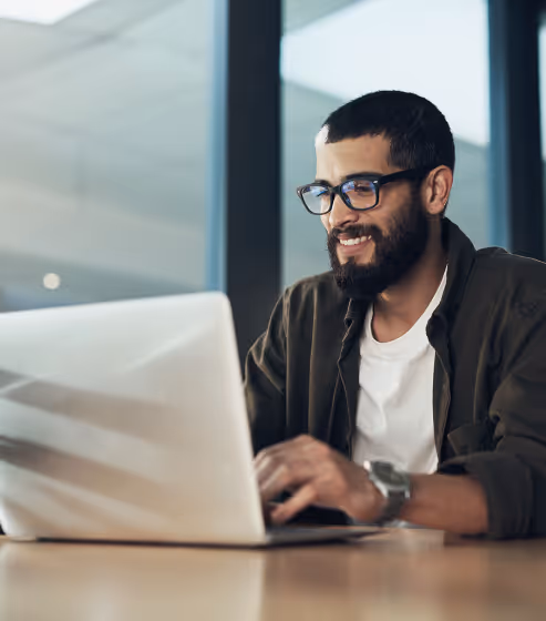 A smiling partner typing on a laptop